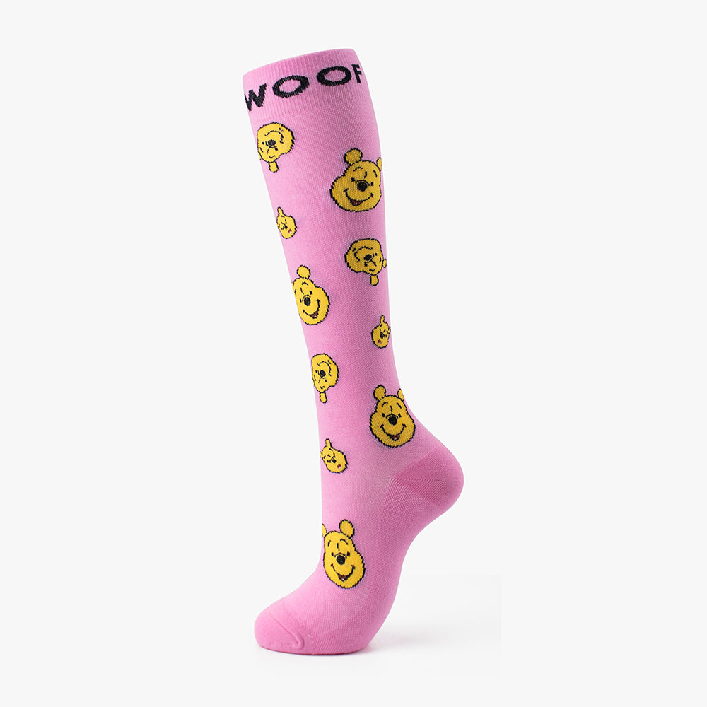 Studio shot of the bright pink pair from the Disney’s Winnie the Pooh Bamboo Compression Socks 6 Pack, showcasing a deep purple "WOOF" cuff band and repeating Winnie the Pooh face illustrations.   