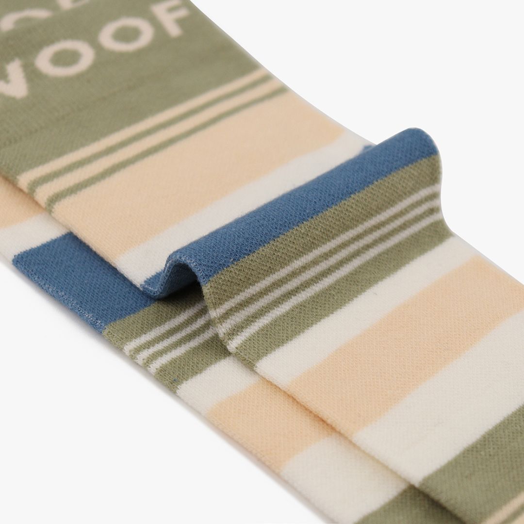 Folded view of striped knee-high compression socks displaying the olive green, cream, and slate blue pattern and top cuff branding.